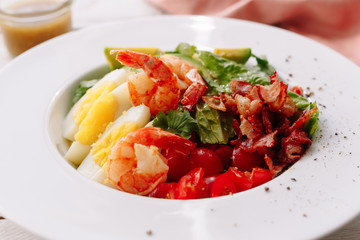 King prawns salad with egg, cherry,  shrimp avocado and vegetables. Sauce. Dinner. Healthy food.