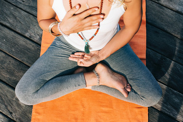 Young Woman Practicing Yoga Heart Meditation on Orange Yoga Rag
