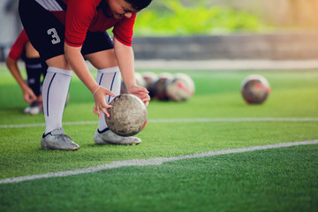 the Asian kid footballers are placing the ball at the penalty spot to prepare for a penalty...