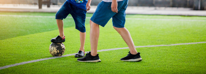 selective focus to Kid soccer and dad are playing ball on at artificial turf, kid and dad are...