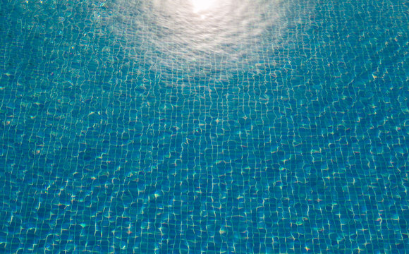 Background of pool water with sun reflection