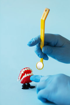 Dentist visiting vampire fake teeth with dental mirror