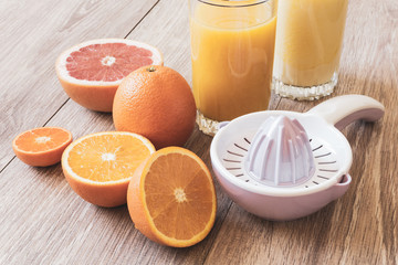 various citrus fruits, reamer and juice
