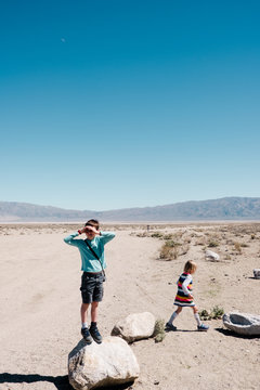 boy and girl playing on rocks in the desert