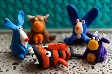 Animals (rabbits, cows and fish) from multi-colored plasticine, which hardens. Children's creativity. Funny clay toys.