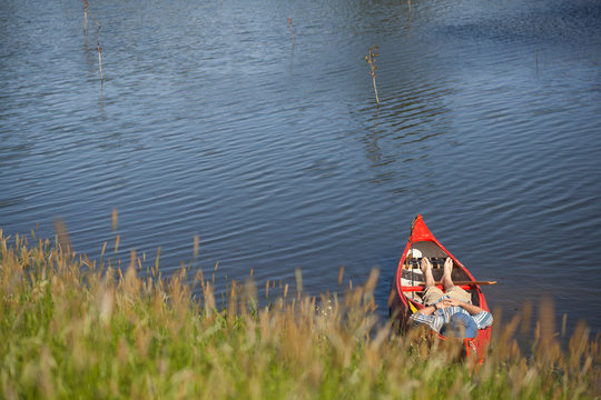 Stock photo of a man resting in a canoe on a summer day