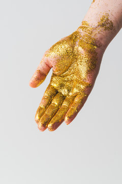 Hand covered in golden glitter