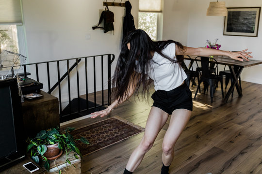 woman sliding across wood floor