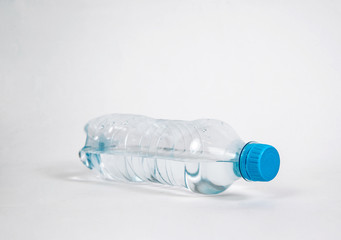 Plastic bottle with water on a light background. The concept of thirst, the desire to drink clean water. Taking care of health, proper hydration of the body.