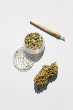 Marijuana bud with grinder and rolled joint