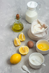 Ingredients for making cake - flour, eggs, milk or buttermilk, olive oil, sugar, lemon, baking powder. Food background. Bake sweet cake dessert concept. Copy space.