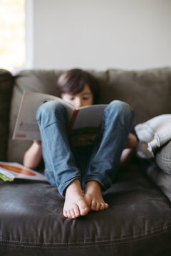 Young boy reading on the couch