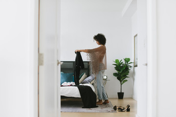Woman picking out clothes in bedroom
