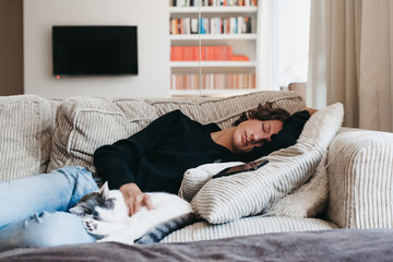 Teen sleeping on the couch with his cat