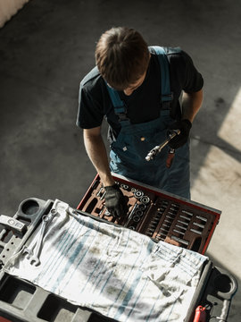 Repairman with tools in cabinet
