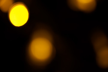 Abstract gold bokeh on black background. Defocused yellow lights, abstract texture