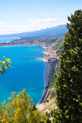 Crystal blue waters of Ionian sea near Taormina resorts and Etna volcano mount in Sicily, Italy. Shiny summer day, vacation destination. 