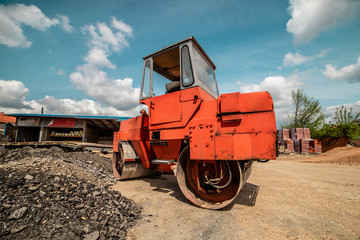 Fototapeta premium Heavy vibration red road roller compactor at the construction site