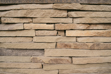 Backdrop of textured uneven gray stone blocks in wall design	