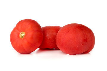 Tomatoes on a white background. Three fresh tomatoes close up.