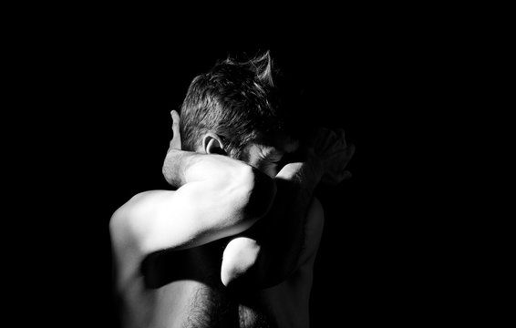 dramatic black and white photography, a man holding his head, in an emotional pose