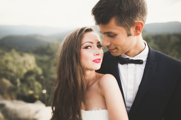 Beautiful wedding couple, bride and groom, in love on the background of mountains