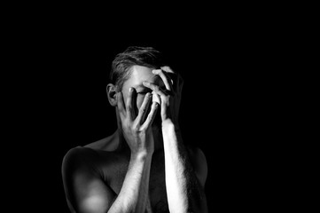 dramatic black and white photography, a man holding his head, in an emotional pose