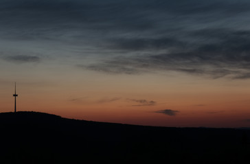 Silhouette signal antenna tower and the sun at sunset sky background