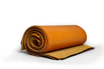 Soft trimmed leathers in thick roll lay down on the table isolated