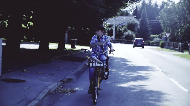 Mail boy throwing newspaper while bicycling