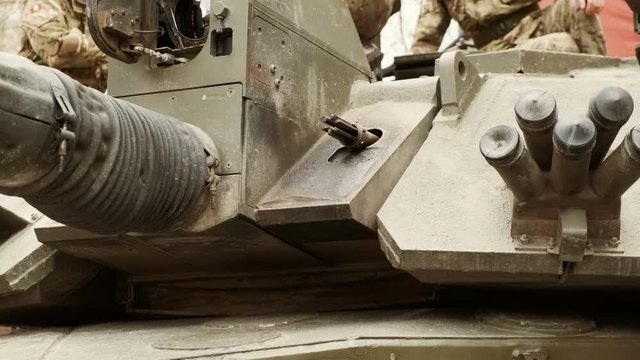 Close-up of a group of soldiers on top of the turret of a war tank