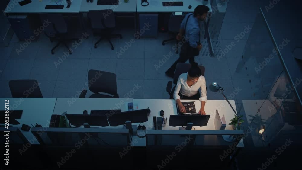 Poster working late at night in the office: businesswoman using desktop computer, analyzing, using document