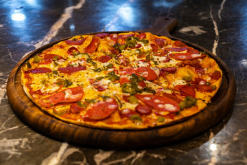 Pizza on black stone background, top view. Pizza with Tomatoes, Basil and Mozzarella Cheese close up