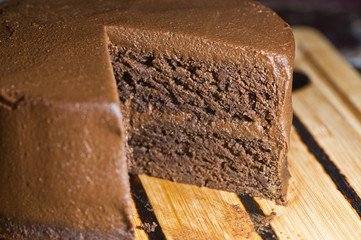 Slice cut from vegan chocolate sweet potato cake on lined cutting board