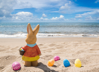 Beach Easter background with bunny and color eggs