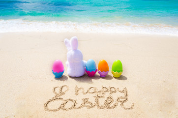 Happy easter background with color eggs on the beach