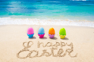 Fototapeta na wymiar Happy easter background with color eggs on the beach
