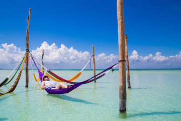 Fototapeta na wymiar Woman resting at Caribbean beach hammock