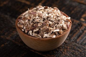 Bowl of Dehydrated Dandelion Root on a Rustic Wooden Table