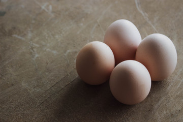 Four chicken organic eggs on rustic wooden background. Spring raw fresh style.