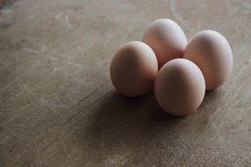 Four chicken organic eggs on rustic wooden background. Spring raw fresh style.