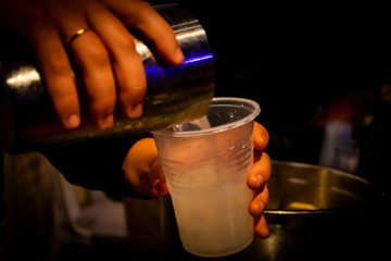 Fototapeta na wymiar Shaker with glass with drink with hands