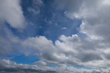 blue sky with white and grey clouds to horizon