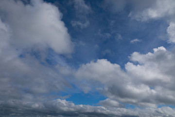 blue sky with white and grey clouds to horizon