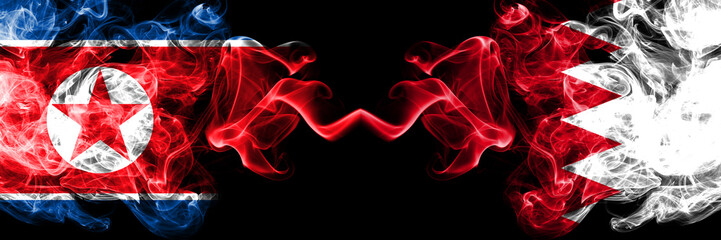 North Korea vs Bahrain, Bahrani smoky mystic flags placed side by side. Thick colored silky smoke flags of North Korea and Bahrain, Bahrani.