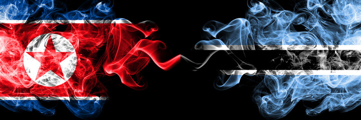 North Korea vs Botswana, Botswanan smoky mystic flags placed side by side. Thick colored silky smoke flags of North Korea and Botswana, Botswanan.