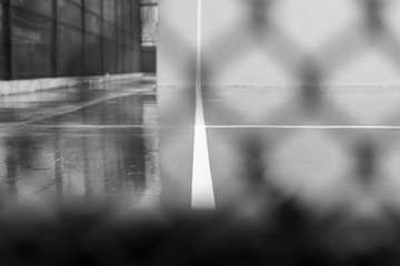 Ball court on a rainy day in New York City's Williamsburg neighborhood in Brooklyn, in black and...