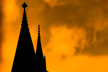 Silhouette of a church steeple, against a bright yellow fiery-looking sky during sunset, Harlem,...