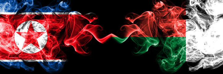 North Korea vs Madagascar, Madagascan smoky mystic flags placed side by side. Thick colored silky smoke flags of North Korea and Madagascar, Madagascan.