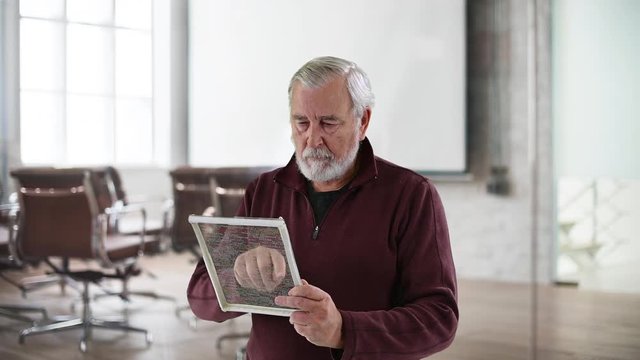 Adult caucasian male editing computer code on a futuristic touchpad screen